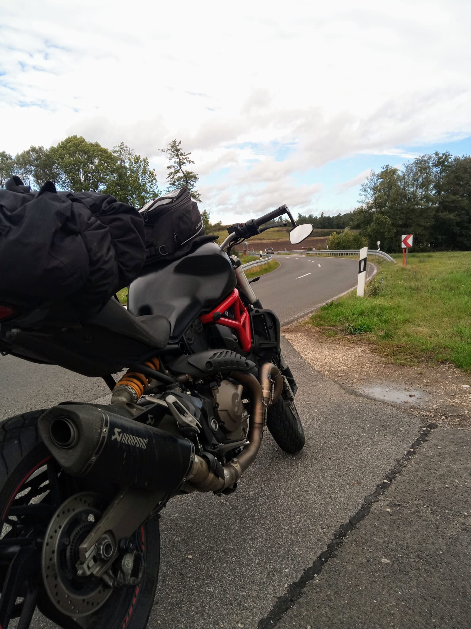 Ducati Monster 821 with luggage right before a curved road